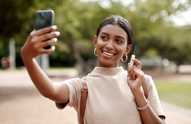 Women holds phone while taking a selfie of herself and a product